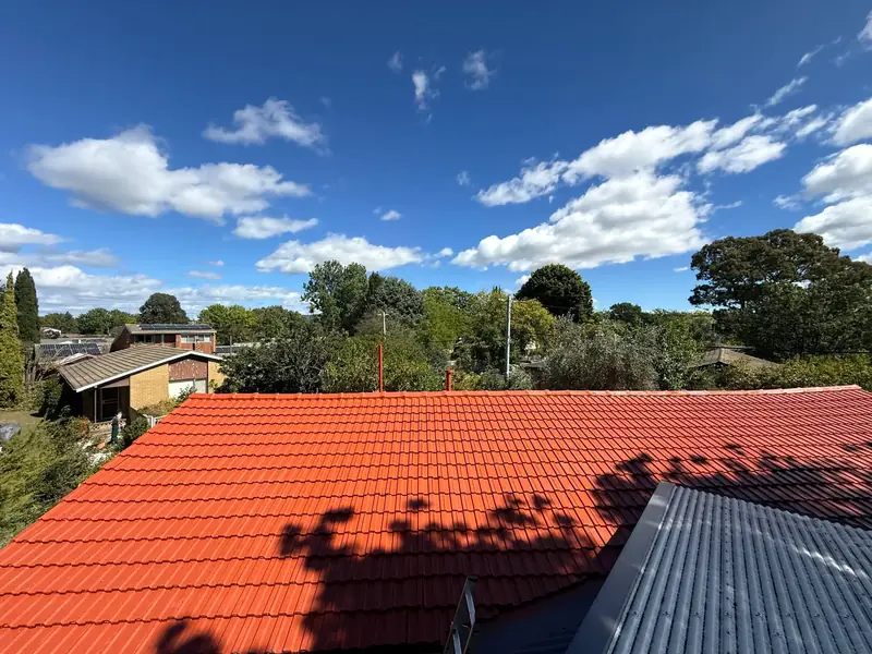 Freshly restored terracotta-red tiled roof under a blue sky