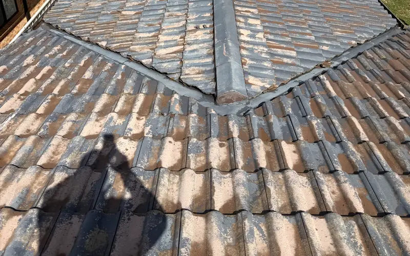 Our roofer on the roof photographing the ridge and valleys during a free inspection