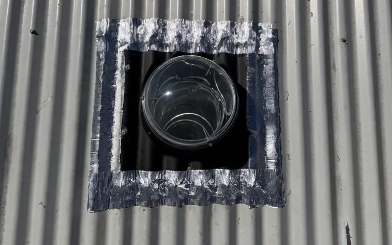 Skylight on a metal roof freshly sealed around the edge to stop a leak